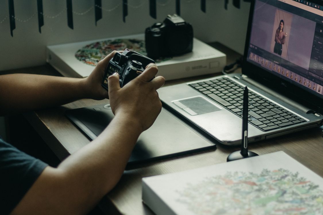 A photographer comparing the best photo editor in mac options on a laptop.